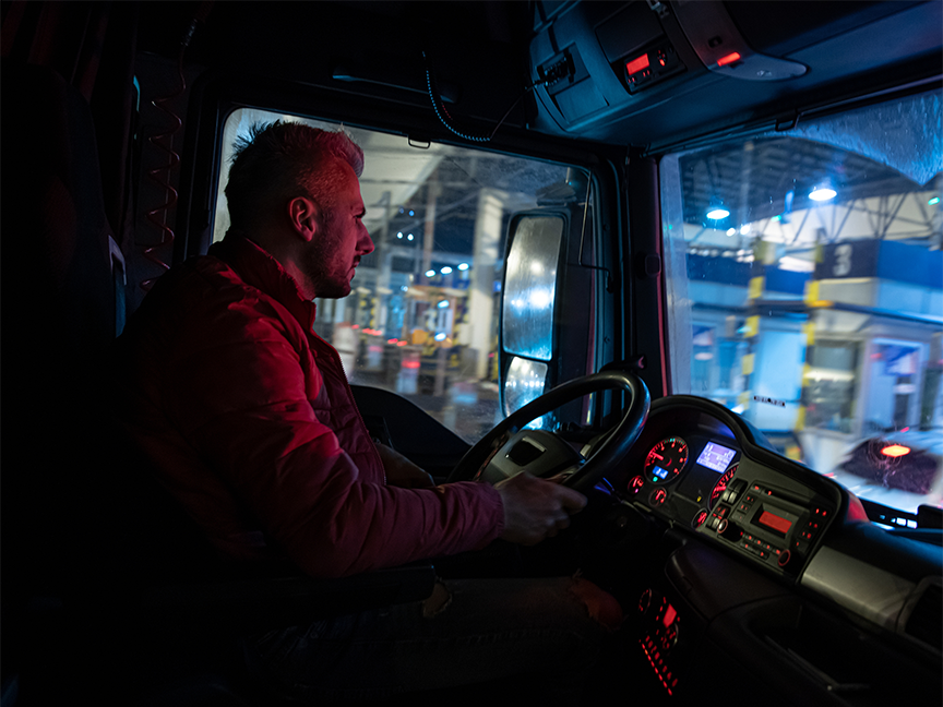 A trucker drives at night.