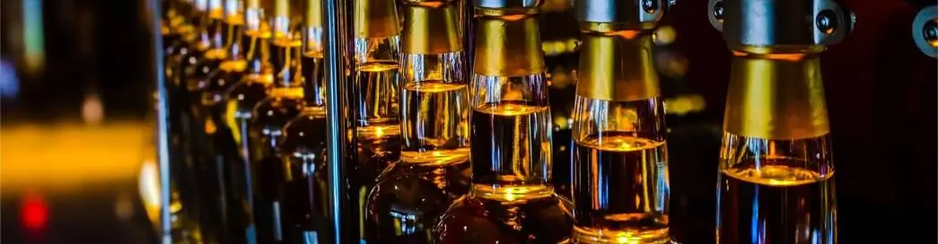 Bottles on a production line being filled with liquid.