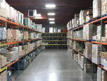 Warehouse aisle filled with boxes on high shelves.